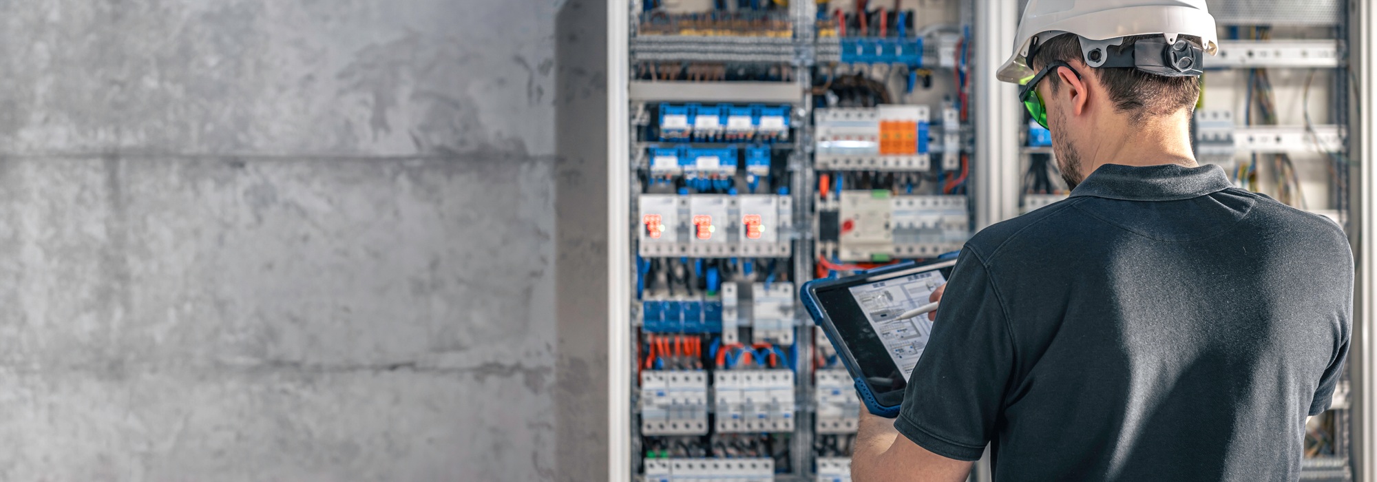 Man, an electrical technician working in a switchboard with fuses.